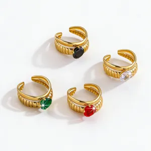 Detail view of stainless steel gold plated open rings featuring colorful zircon stones.