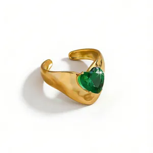 Detailed closeup shot of a gold plated stainless steel green heart cubic zirconia ring