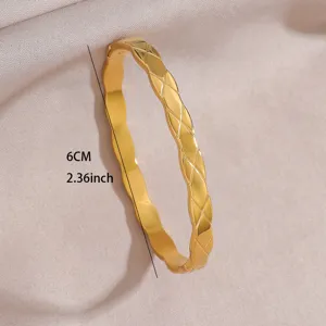 Close-up view of a gold-plated diamond lattice patterned bangle bracelet with elegant wavy edges.