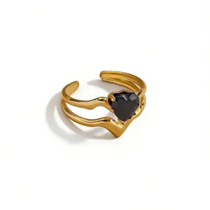 Detailed view of gold plated open ring featuring unique wavy double band and black heart stone.