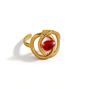 Close-up detail of the gold-plated stainless steel ring featuring a sparkling red oval zircon stone.