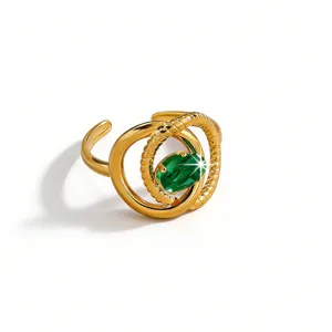 Gold plated stainless steel snake ring detail with green zircon gemstone sparkle close up