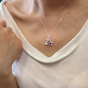 Nahaufnahme einer Halskette aus 925er Sterlingsilber mit bunten Sternanhängern.
