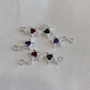 Detailansicht von Sterlingsilber-Sternanhängern mit farbigen herzförmigen Zirkoniasteinen.