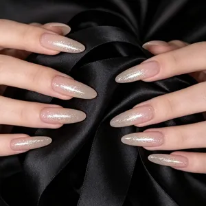 Close-up of sparkling silver glitter top coat on almond-shaped nude gradient nails