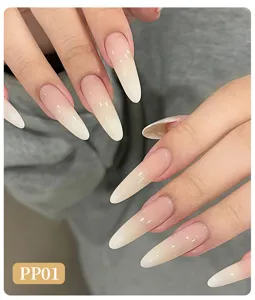 Close-up detail of long almond nails featuring elegant nude and white ombre blush gradient effect