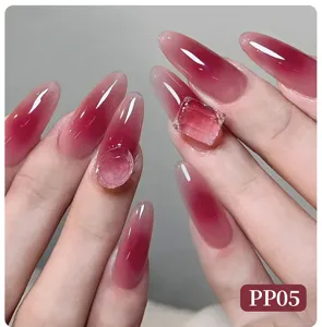 Close-up detail of almond shaped blush nails with pink gradient and 3D ice cube gemstones