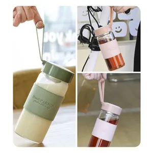 Portable glass water bottle with sleeve and strap, minimalist transparent cup for summer.