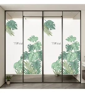 Detailaufnahme einer dekorativen Fensterfolie mit Monstera-Blättern im Aquarell-Stil