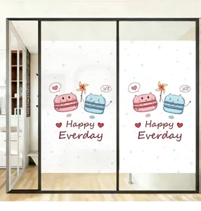 Close-up of frosted window film featuring cute cartoon macaron cats design.