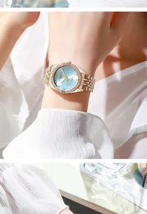 Detailed view of an elegant women's watch with diamond bezel and light blue dial on wrist