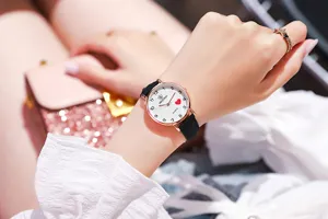Detailopname van elegant dameshorloge met zwarte leren band en hartmotief op de wijzerplaat