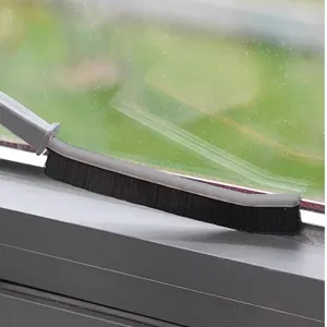 Close-up detail of cleaning brush scrubbing window track and narrow gap efficiently.