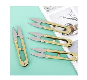 Gold U-shaped thread scissors detail shot, spring yarn snippers for sewing and cross stitch.