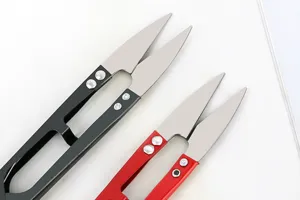 Detail view of U-shaped thread scissors with sharp metal blades and spring handles for sewing.