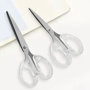 Stainless steel blade and transparent handle detail of student craft scissors for DIY art.