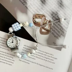 Dettaglio ravvicinato di un grazioso orologio con cinturino di perline e piccolo quadrante bianco