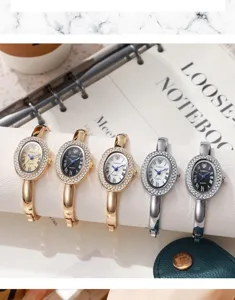 Nahaufnahme eleganter Damen-Armreifuhren mit Strass-Lünette und römischen Ziffern.
