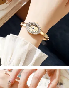 Nahaufnahme der eleganten goldenen Ovaluhr mit Diamantlünette und römischen Ziffern