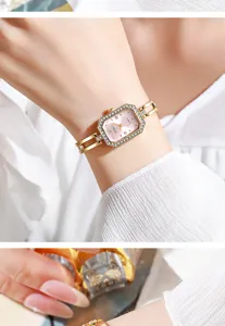 Nahaufnahme einer eleganten goldenen Armbanduhr mit rosafarbenem Zifferblatt für Damen