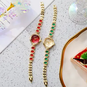 Montres bracelets dorées pour femmes avec pierres précieuses rouges et vertes en vue de détail.