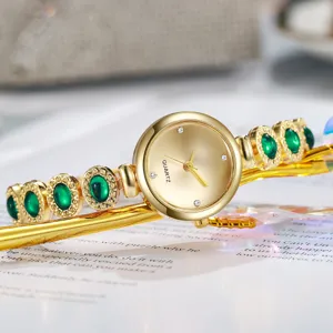 Élégante montre-bracelet dorée avec pierres vertes façon émeraude et mouvement à quartz