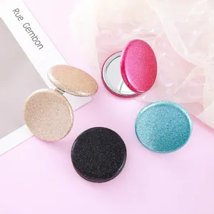 Portable double-sided folding makeup mirror with glitter finish, compact pocket cosmetic mirror.