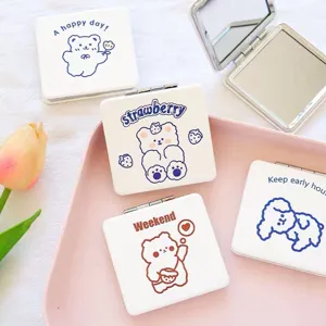 Portable compact makeup mirror with cute cartoon bear design, double-sided folding cosmetic mirror.