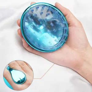 Detail of blue scalp massage brush with ergonomic handle held in hand for hair washing