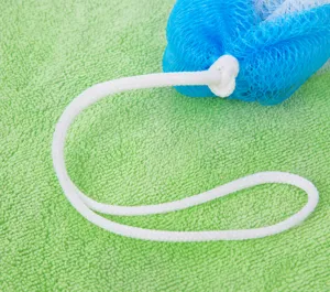 Close-up detail of the soft mesh bath sponge featuring a convenient cotton hanging rope design.
