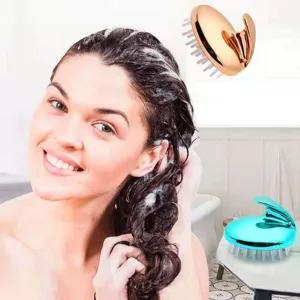 Detailed view of silicone scalp massage hair brush in gold and teal for hair washing