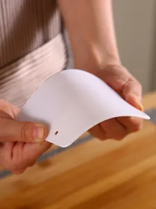 Vue detaillee du racloir a pate en plastique, racloir flexible blanc pour la patisserie.