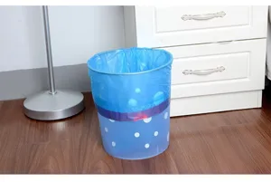 Vue détaillée de sacs poubelle colorés avec lien coulissant et poubelle à pois bleue assortie.