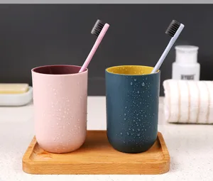 Minimalist double-color mouthwash cup set with toothbrush, bathroom sink detail view.