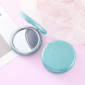 Portable double-sided folding cosmetic mirror with sparkling blue glitter finish for daily use.