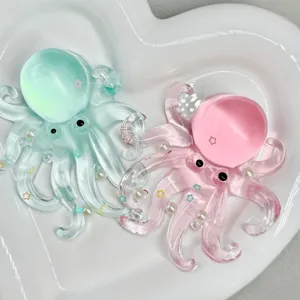 Close-up detail of cute translucent octopus squeeze toys with tiny stars and pearls in a white tray.
