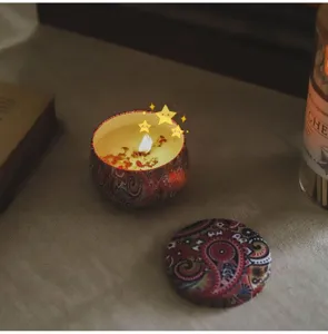 Bougie parfumée artisanale aux fleurs séchées dans une boîte métallique décorative chic.