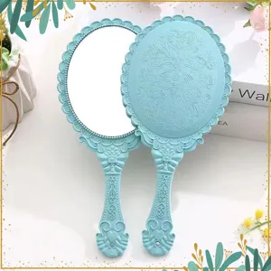 Vintage handheld makeup mirror with embossed European style lace design, clear mirror face.