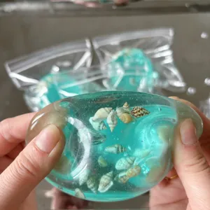 Detailansicht von handgefertigtem blauem transparentem Quetschspielzeug mit Muscheln.