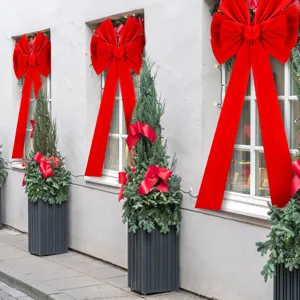 Giant oversized Christmas velvet decorative bow with long streamers for outdoor holiday yard decor.