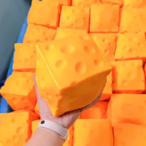 Dettaglio di un enorme giocattolo antistress al formaggio in mano, morbido, rimbalzo lento.
