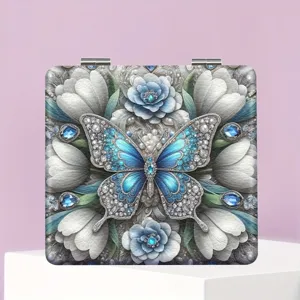Detailansicht des tragbaren Klappspiegels mit 3D blauer Schmetterling und Kristallrelief.