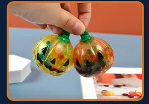 Close up of Halloween pumpkin squeeze toy with colorful water beads for sensory relief.