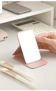 Portable folding makeup mirror for convenient daily desktop use with sleek pink leather stand.