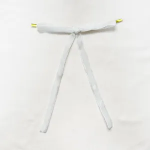 White velvet ribbon detail showing gold metallic ends and soft texture hanging ornament.