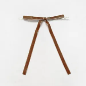 Exquisite brown velvet bow detail shot showcasing soft texture and elegant long hanging tails.