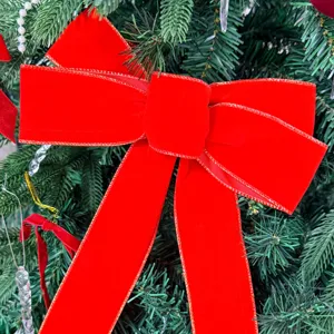 Red velvet Christmas bow ornament with gold trim, perfect for holiday tree decoration.