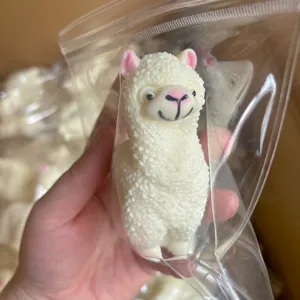 Close-up detail shot of the cute white alpaca squeeze toy showcasing its soft texture.