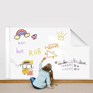 A young child drawing colorful patterns on a large static whiteboard wall sticker