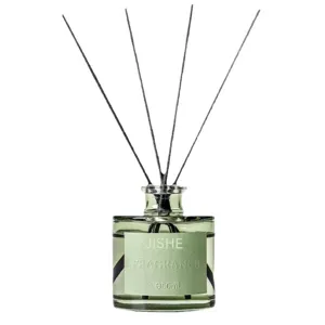 Green glass bottle reed diffuser with black sticks for home fragrance and air freshener use.